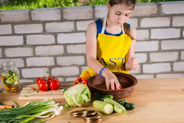 Jong meisje wassen, groenten zoals ze hen flessen — Stockfoto