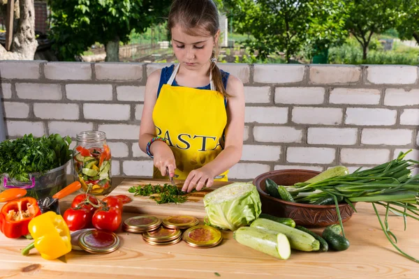 Молодая девушка режет свежие овощи для розлива — стоковое фото