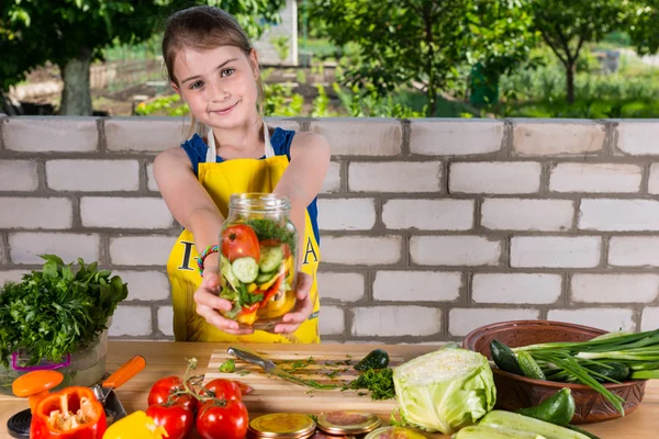 Dziewczynka gospodarstwa słoik pełen świeżych warzyw cięcia — Zdjęcie stockowe