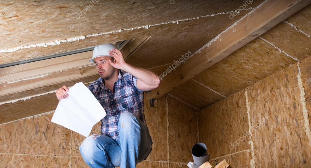 Builder Reading Plans Inside Unfinished Home Stock Photo by ©Vaicheslav