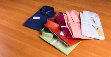 New Colorful Dress Shirts Fanned on Wooden Surface clipart