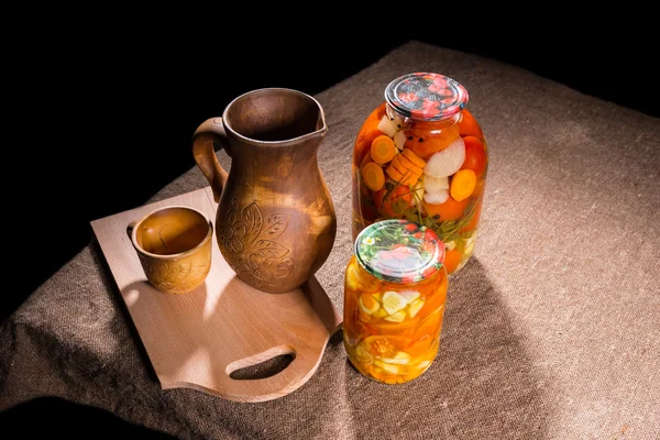 Üvegek, savanyúság és fából készült asztal — Stock Fotó