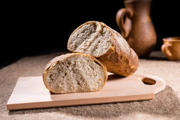 Celozrnný bochník chleba na dřevěné prkénko — Stock fotografie