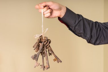 Male Hand Holding String of Antique Rusty Keys clipart