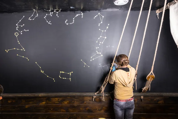 Woman Painting Star Constellations on Blackboard — Stock fotografie