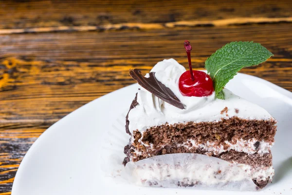 Creamy tasty chocolate cake with a cherry — Stock Photo, Image