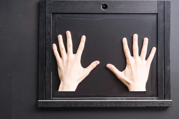 Two hands on black window hatch — Stockfoto