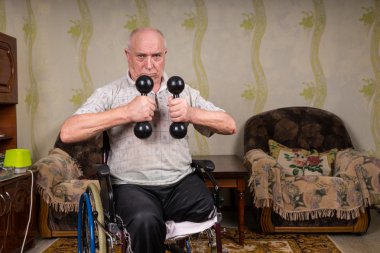 Senior Man in Wheelchair Lifting Dumbbells at Home