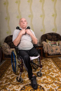 Senior Man in Wheelchair Holding Dumbbells at Home