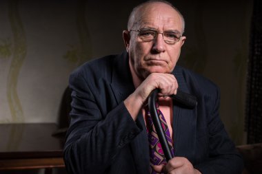 Serious Middle Aged Businessman Holding his Cane