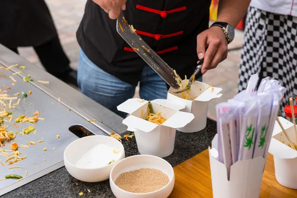 Chef servindo macarrão asiático em tirar recipientes — Fotografia de Stock