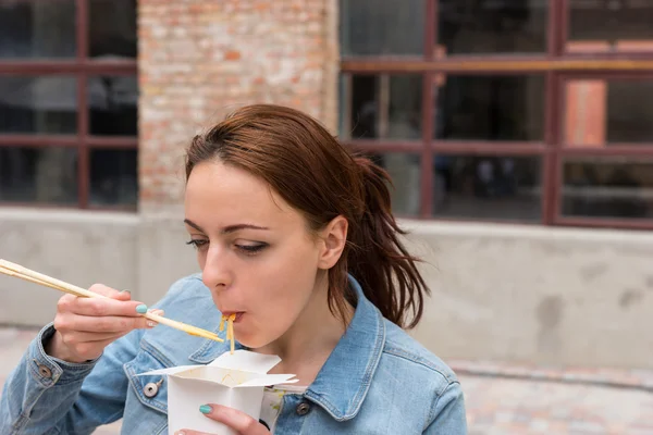 Mujer comiendo sacar fideos con palillos — Foto de Stock