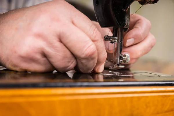 Männliche Hände fädeln Nadel der Nähmaschine ein — Stockfoto