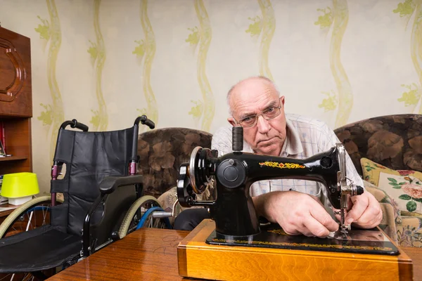 Senior man using a mechanical sewing machine — Stok fotoğraf