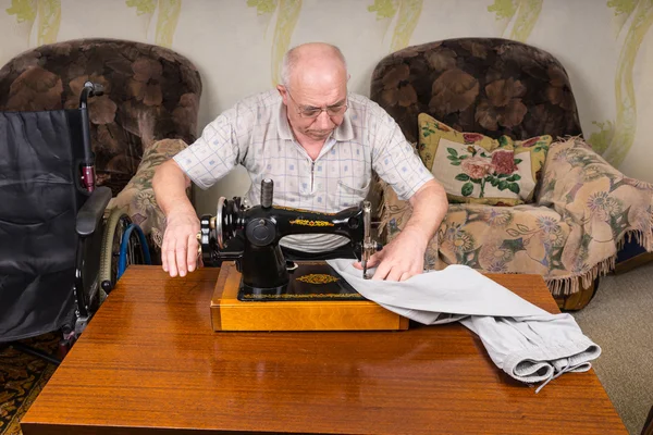 Homem sênior usando a máquina de costura à moda antiga — Fotografia de Stock
