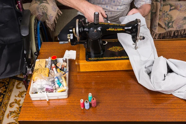 Hombre mayor usando la máquina de coser de moda antigua — Foto de Stock