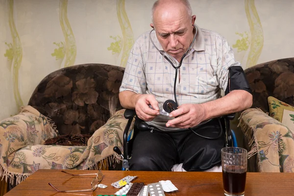 Chauve vieil homme Vérification des médicaments avec appareil BP — Photo