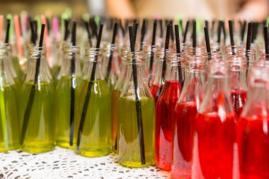 Close Up of Red and Green Sodas with Black Straws