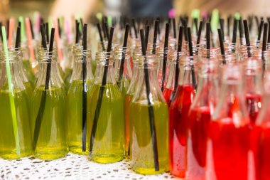Variety of Sodas in Open Glass Bottles with Straws