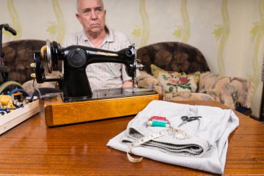Tailor at the Table with Sewing Tools and Cloth