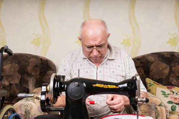 Senior Man with Red Thread at Sewing Machine — Stok fotoğraf