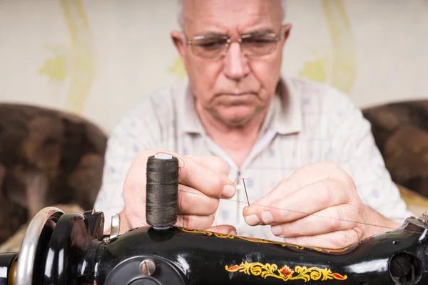 Agulha de rosca de homem sênior da máquina de costura — Fotografia de Stock