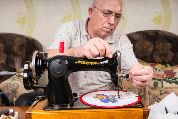 Hombre mayor haciendo aguja en la máquina de coser — Foto de Stock