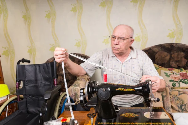 Hombre mayor con cinta métrica y máquina de coser — Foto de Stock