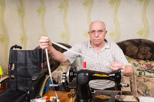 Senior mit Maßband an Nähmaschine — Stockfoto