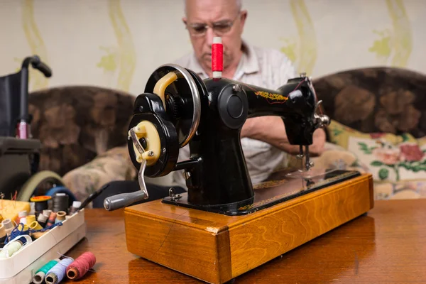 Hombre mayor con máquina de coser Vintage en casa — Foto de Stock