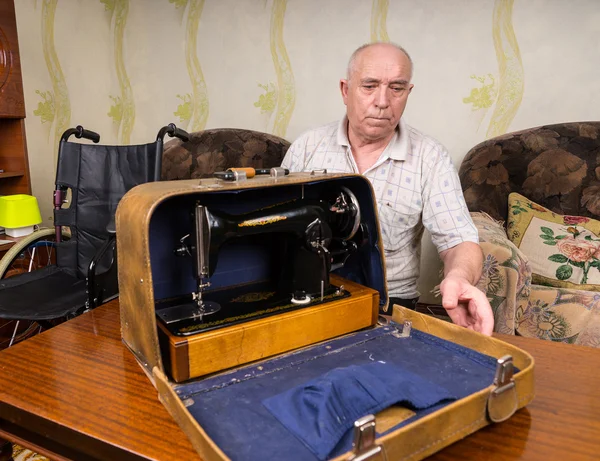 Viejo sastre cerrando un caso con máquina de coser — Foto de Stock