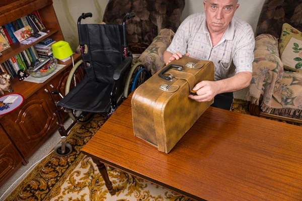 Uomo anziano Chiusura di un caso di macchina da cucire sul tavolo — Foto Stock