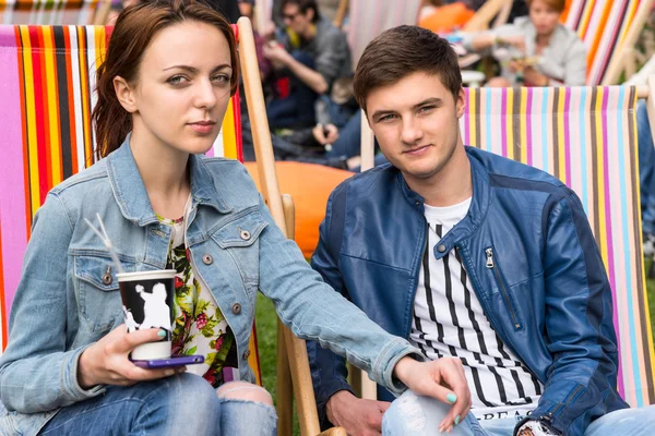 Pareja joven sentada en sillas en un evento al aire libre — Foto de Stock