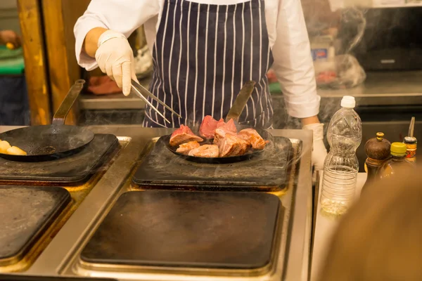 Chef-kok koken van vlees over een bakplaat — Stockfoto