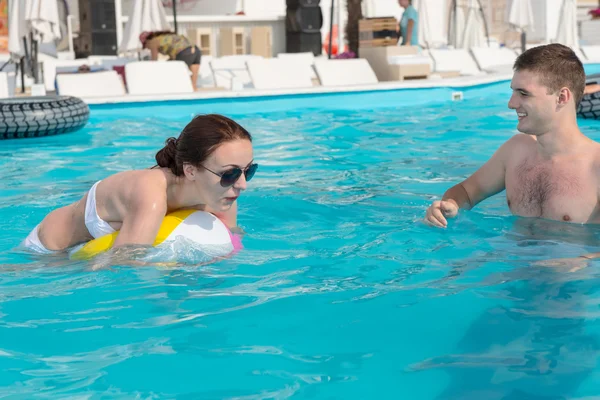 Young Couple Playing with Beach Ball in the Pool