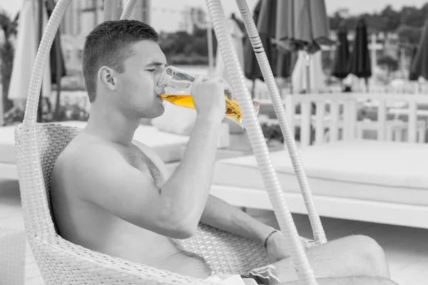 Young Man Drinking Glass of Beer on Resort Patio — Stock Photo, Image