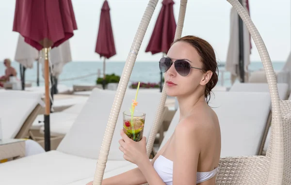 Молодая женщина с тропическим напитком на курорте Патио — стоковое фото