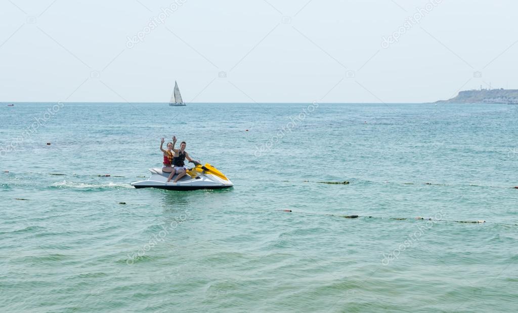 Young couple waving from a jet ski