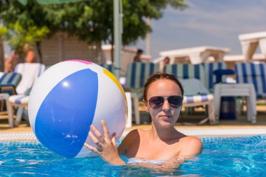 Yüzme havuzunda plaj topu olan kadın