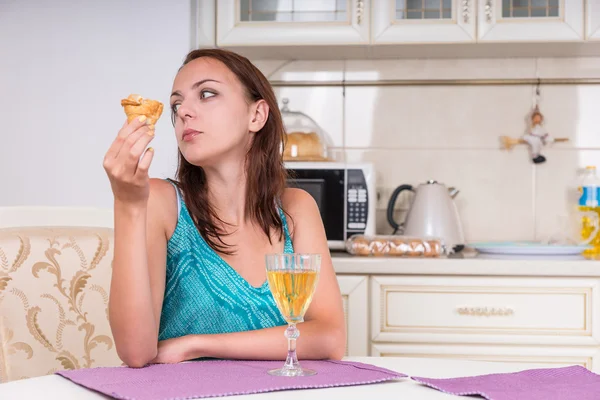 Töprengő nő cookie-kat és a bor a konyhában — Stock Fotó