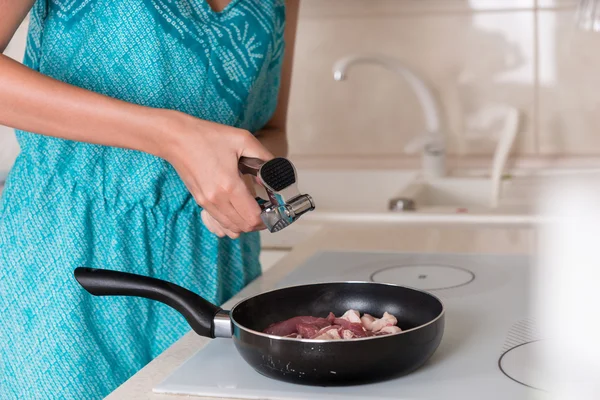 Donna schiacciare aglio fresco per aromatizzare la carne — Foto Stock