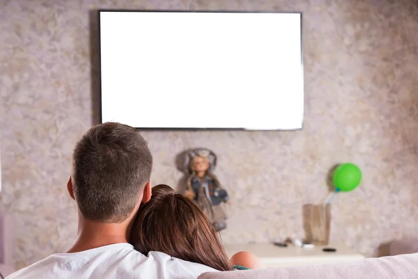 Pareja acurrucándose juntos en el sofá y viendo la televisión —  Fotos de Stock