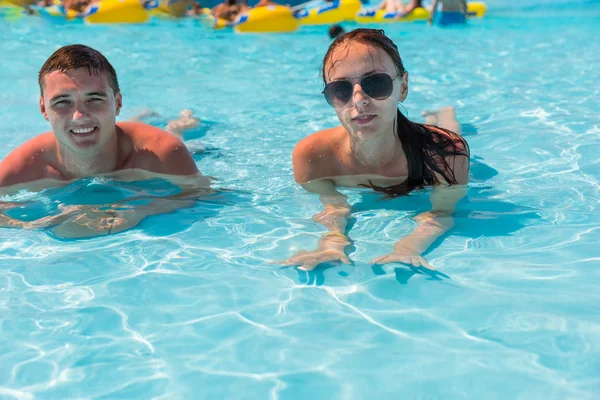 Junges Paar liegt im Untiefen des Swimmingpools — Stockfoto