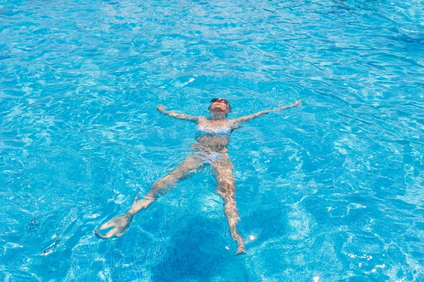 Mujer en bikini flotando en la piscina — Foto de Stock