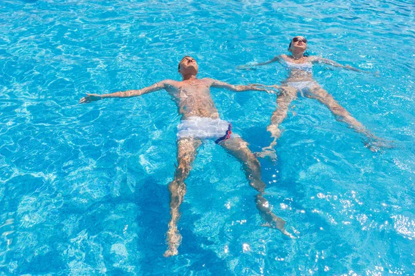 Pareja flotando en respaldos en la piscina del Resort — Foto de Stock