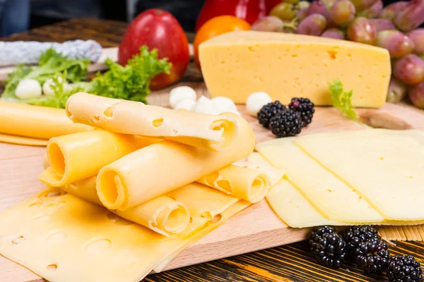 Tablero de queso gourmet adornado con fruta fresca — Foto de Stock