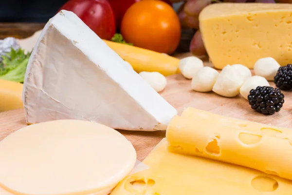 Tabuleiro de queijo gourmet decorado com frutas frescas — Fotografia de Stock