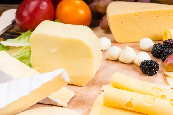 Tabuleiro de queijo gourmet decorado com frutas frescas — Fotografia de Stock