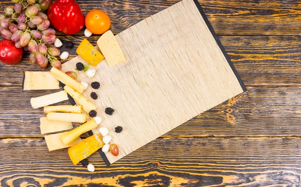 Ξύλινη σανίδα με τυρί και φρούτα σε ρουστίκ πίνακα — Φωτογραφία Αρχείου
