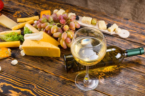 チーズとフルーツのテーブルの上の白ワインのガラス — ストック写真